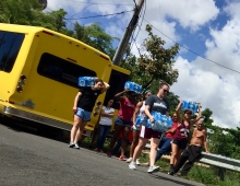 students carrying supplies from a bus